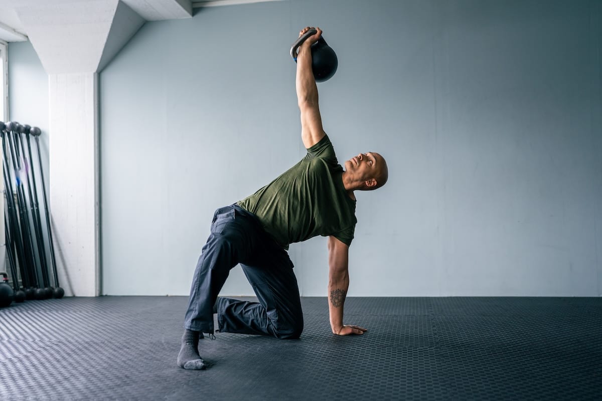 Coach Sami Obele demonstrating a kettlebell Turkish Get Up as part of an online strength and movement course.